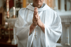 priest praying with a rosary