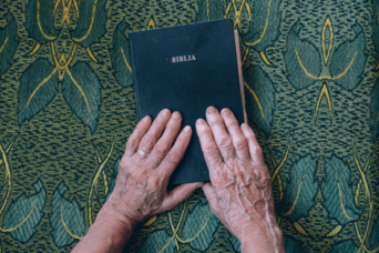 old hands holding the bible