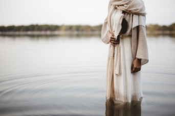woman wearing biblical robe in water