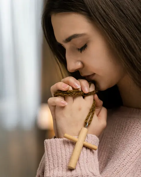 woman praying holding wooden cross