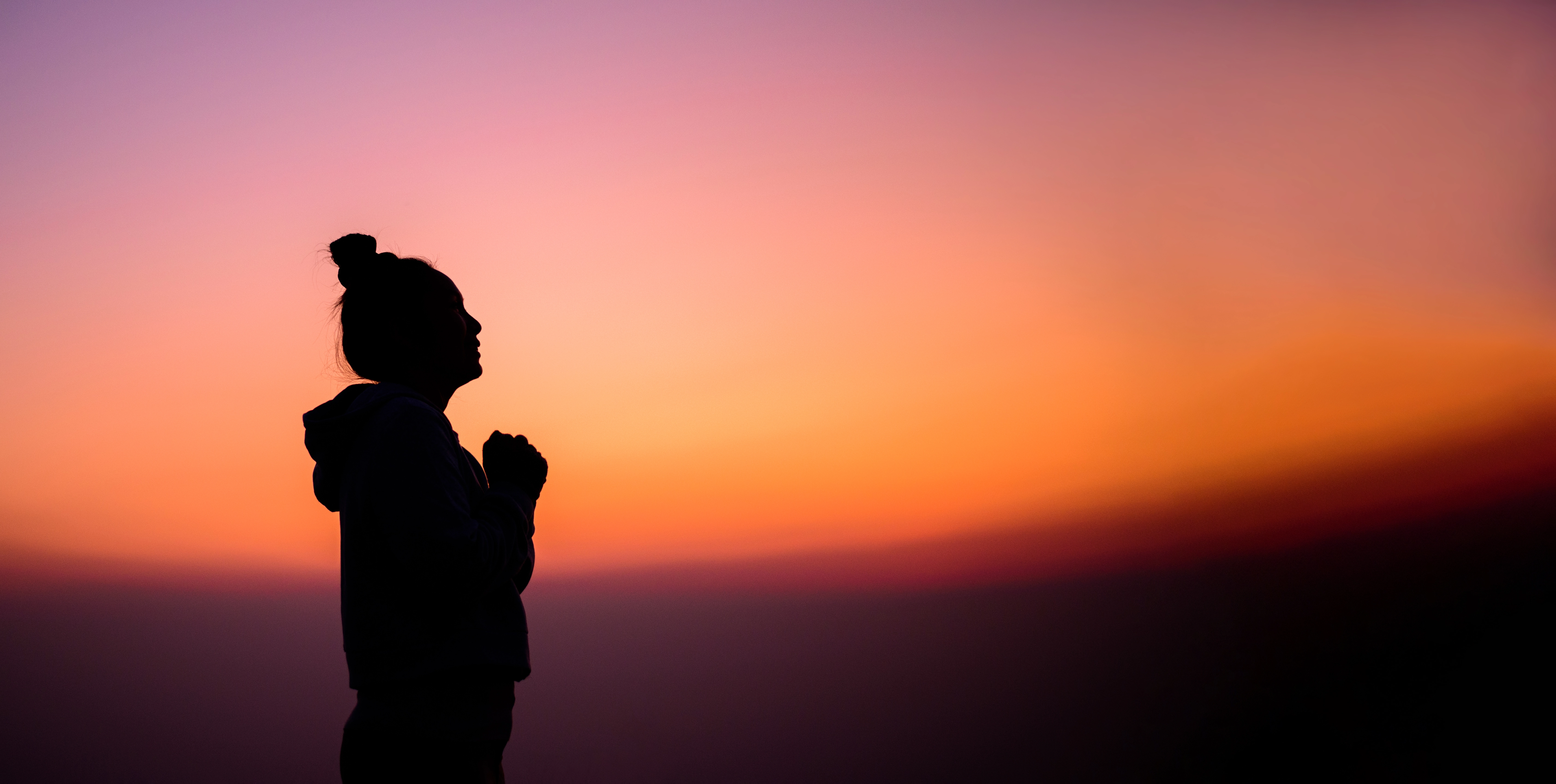 woman praying peaceful sunset