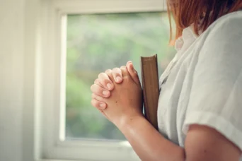 young woman praying with bible